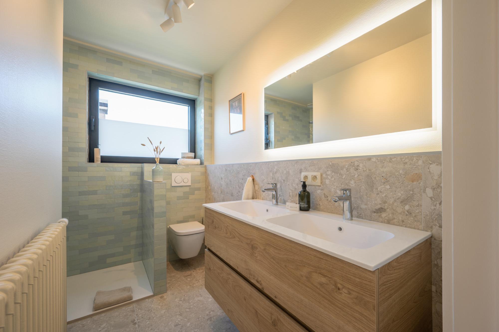 Badkamer met dubbele wastafel en inloopdouche