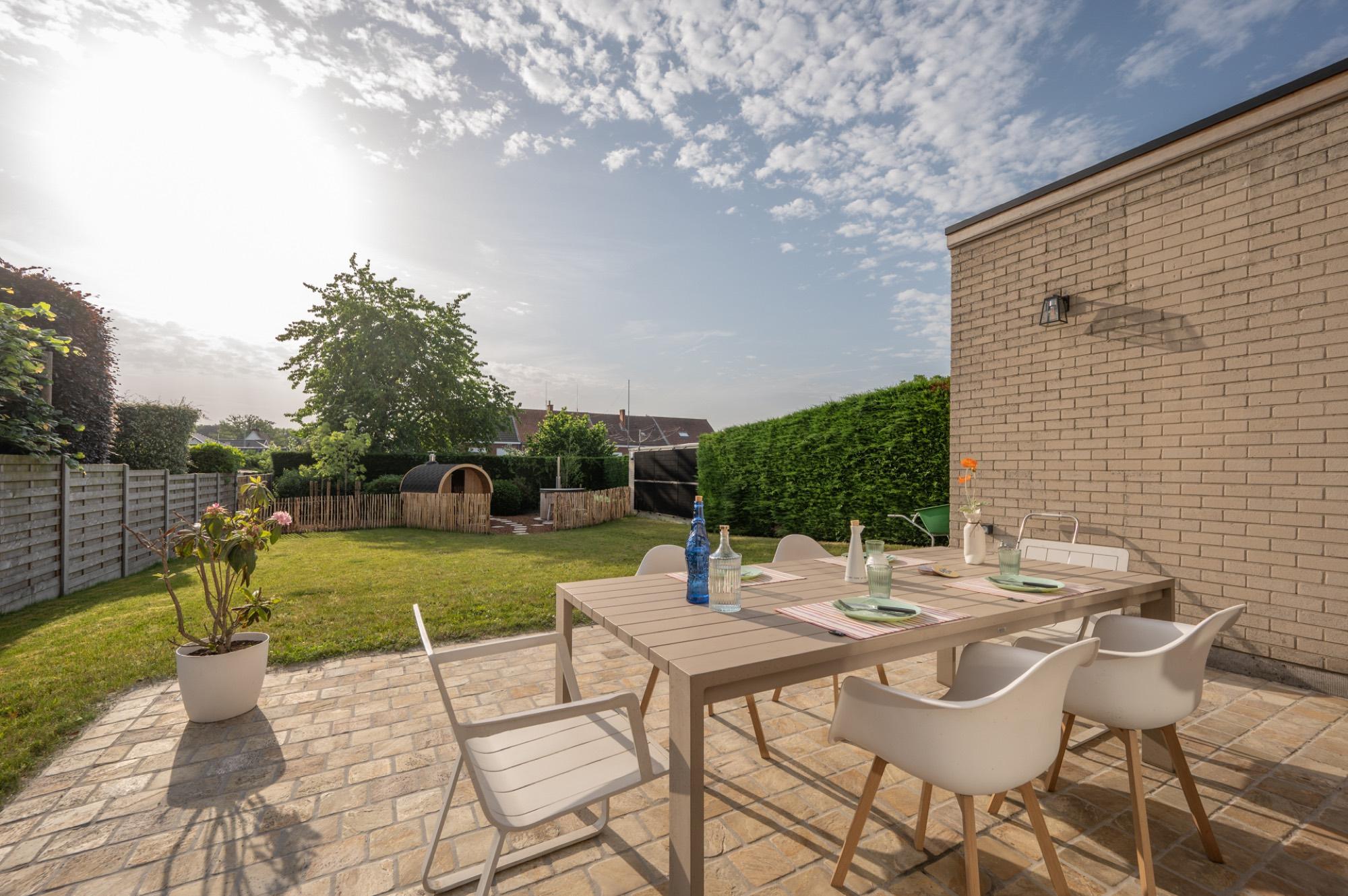 Terras met houten eettafel en tuin